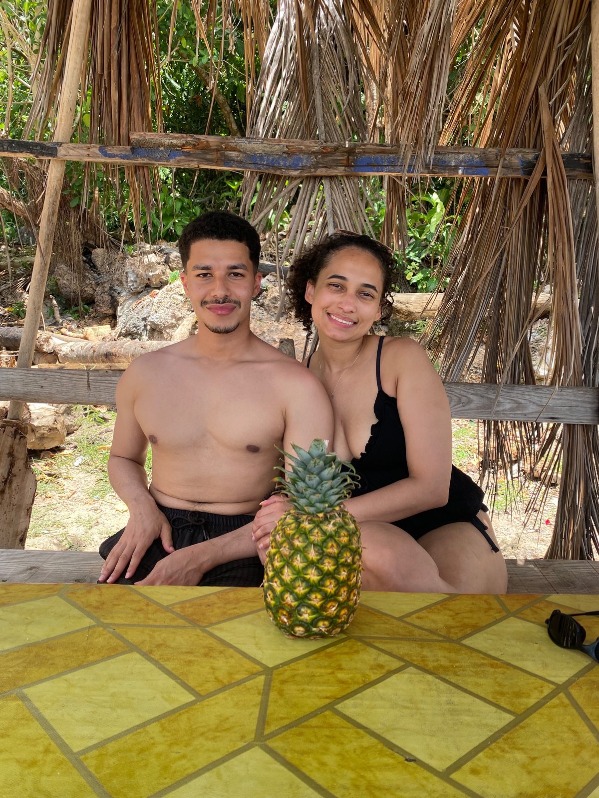 Guests enjoying fresh pineapple at a beach palapa